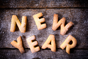 New Year text with cookies on the wooden background